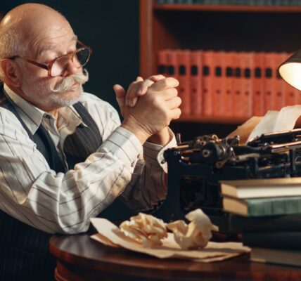 elderly-writer-thinks-at-vintage-typewriter-2023-11-27-05-04-33-utc