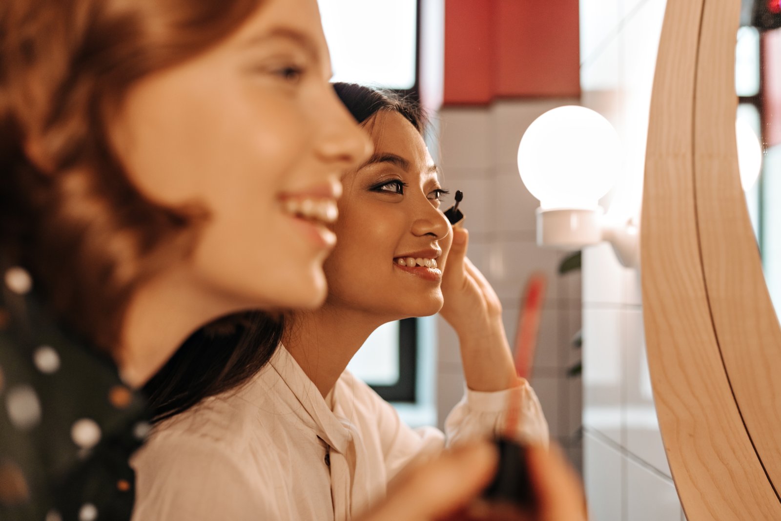 Prezent, który daje chwilę dla siebie – jak świadomie wybierać kosmetyki dla mamy po 30. roku życia? 5 women applying makeup together in bright bathroom 2026 09 24 02 47 44 utc